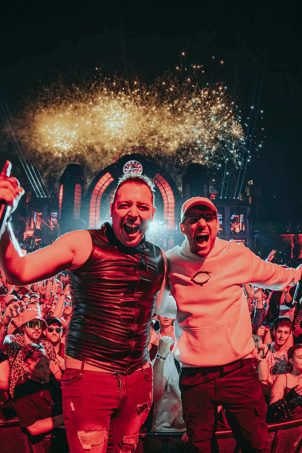 Nils und Niklas von HBz jubeln auf der Bühne vor dem Publikum, im Hintergrund ein Feuerwerk